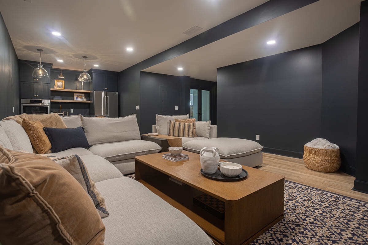 Finished Cincinnati basement featuring open lounge space, sectional sofa, and access to adjacent rooms