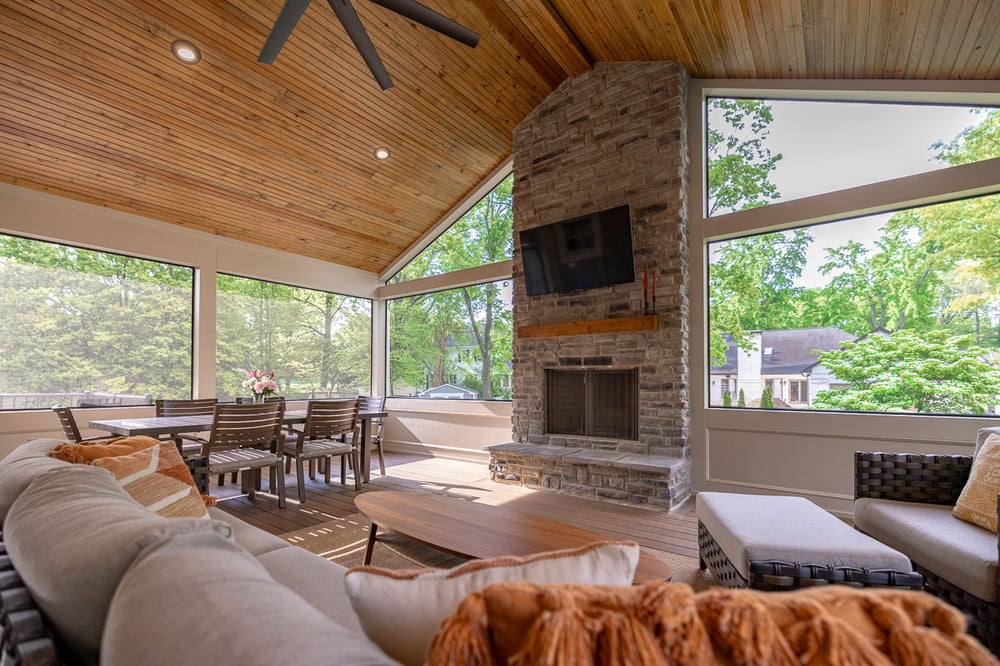 Screened porch with vaulted wood ceiling, stone fireplace, and TV in Greater Cincinnati