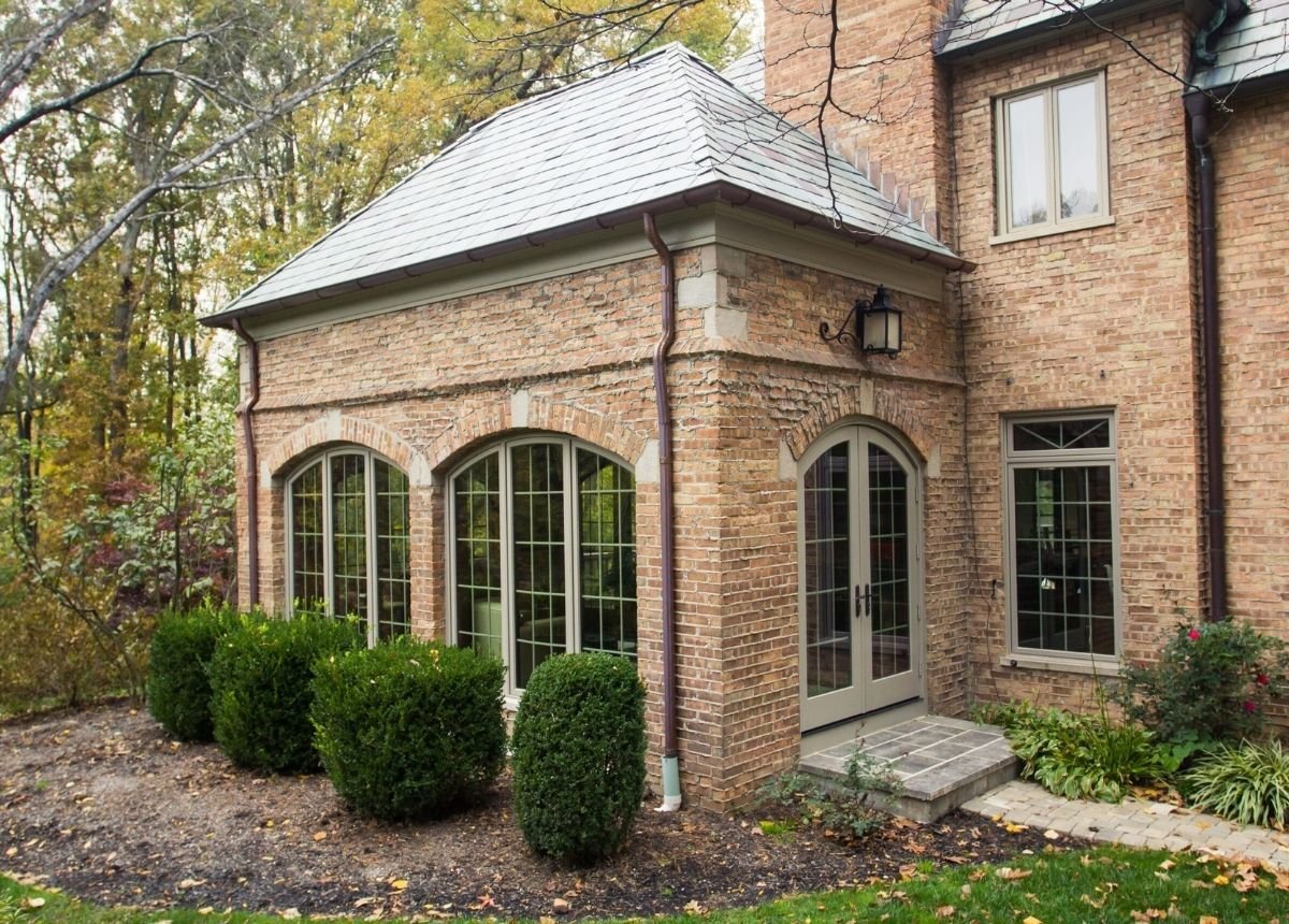 Brick home addition with arched windows and French doors blending with the original architecture located in Cincinnati