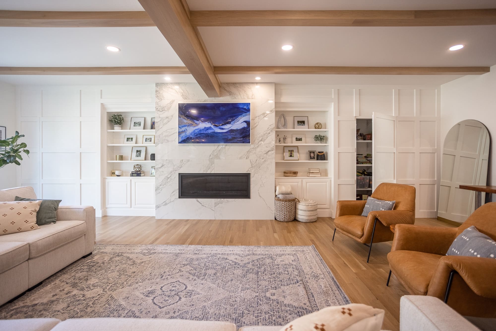 Bright living room with marble fireplace, built-ins, and wood beams in Cincinnati