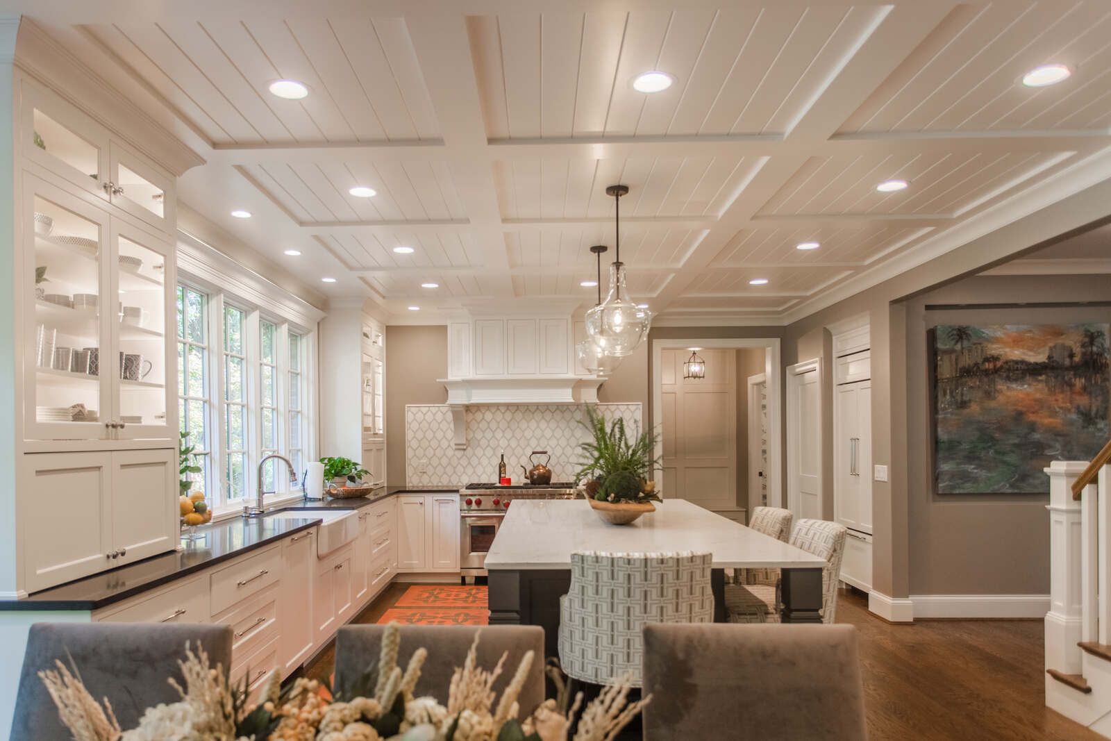Cincinnati kitchen with coffered ceiling, large island, white cabinetry, and built-in window shelving