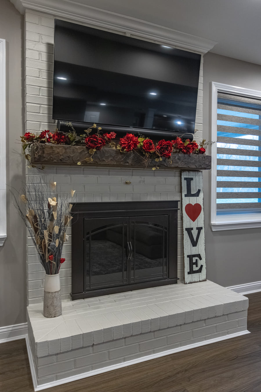 Custom fireplace in Ross County, OH basement with gray stacked brick and mounted TV