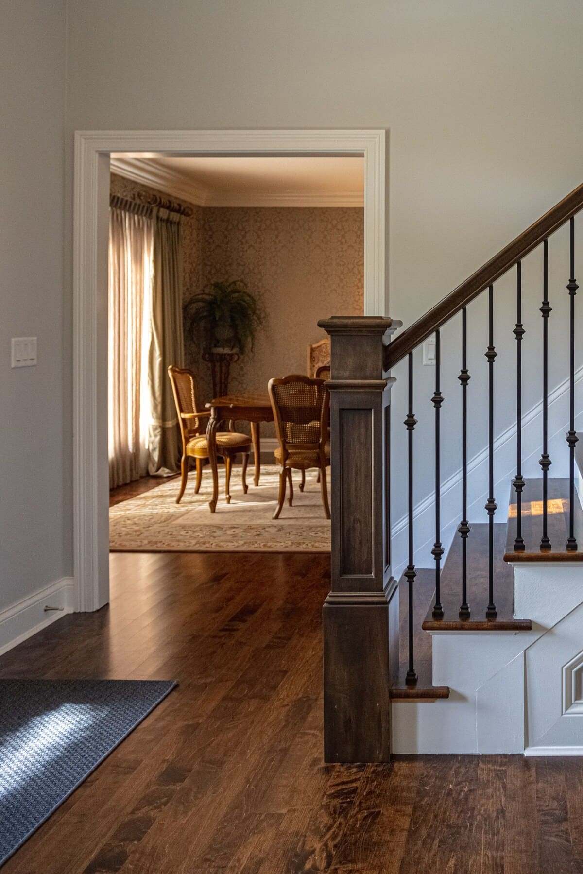 View of dining room area from foyer of home with staircase in front