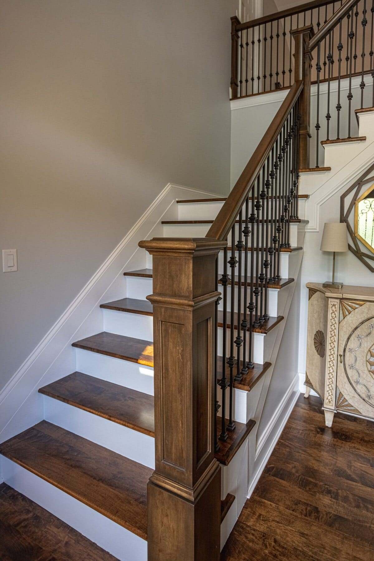 Staircase detail in two-story foyer with maple newel posts