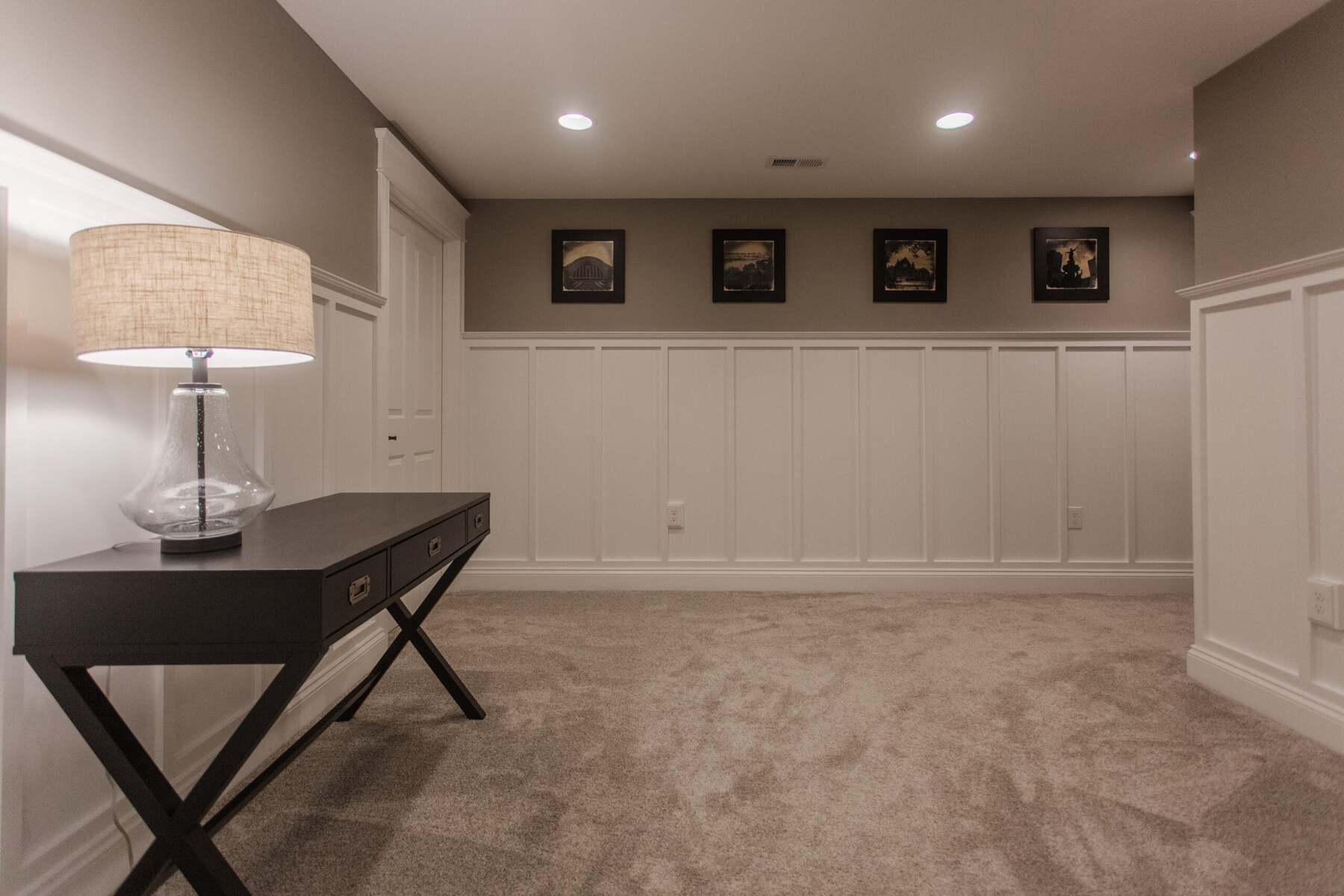 Amberly Village, OH basement sitting area with carpet, wainscoting, framed art, and lamp table