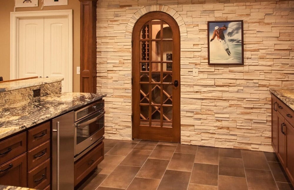 Arched door to wine cellar in Cincinnati basement with large format floor tiling