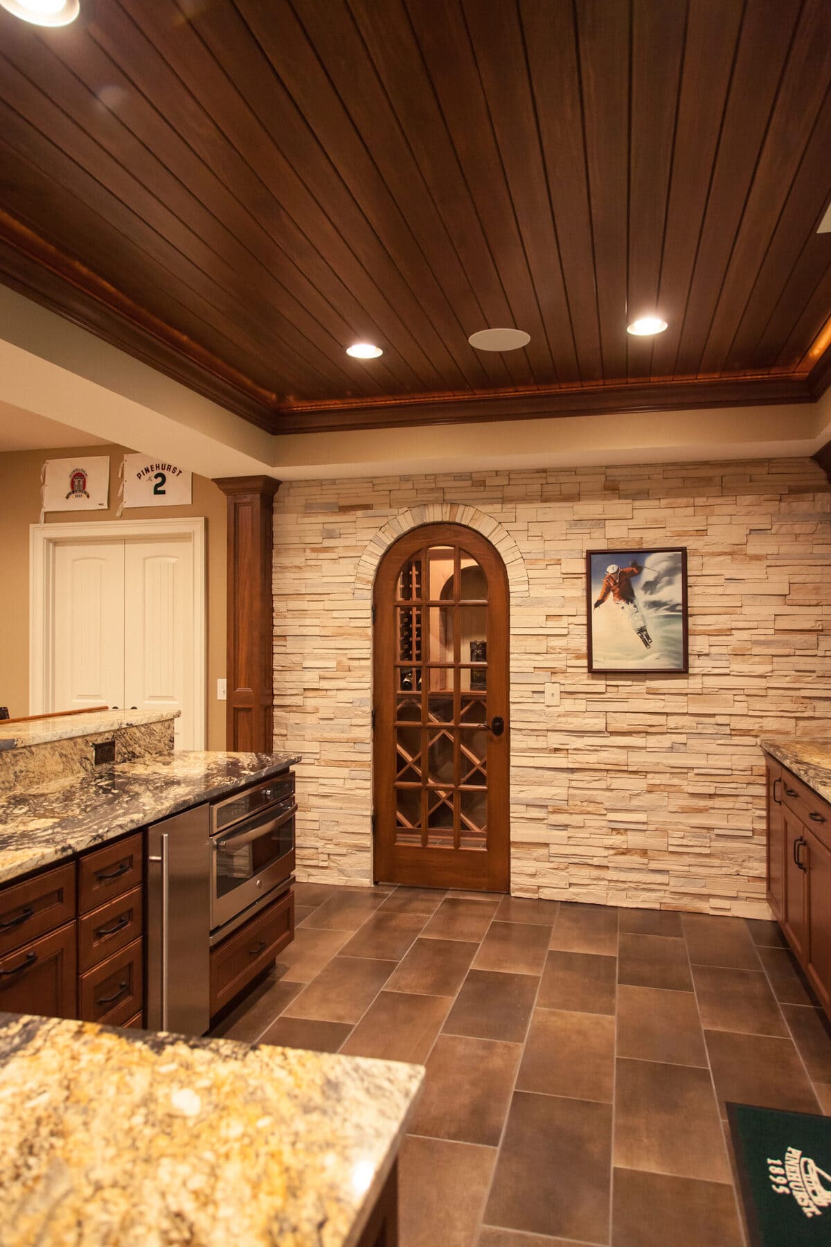 Arched door to wine cellar in Cincinnati basement with large format floor tiling 