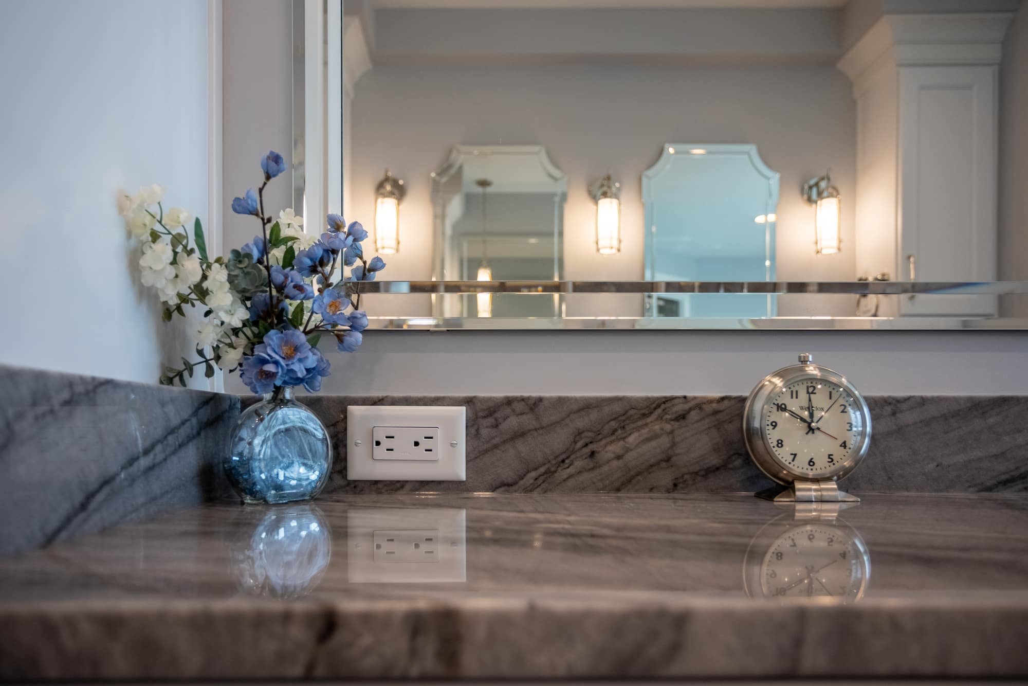 Bathroom countertop with marble surface, clock, and decor by Legacy Builders Group in Greater Cincinnati