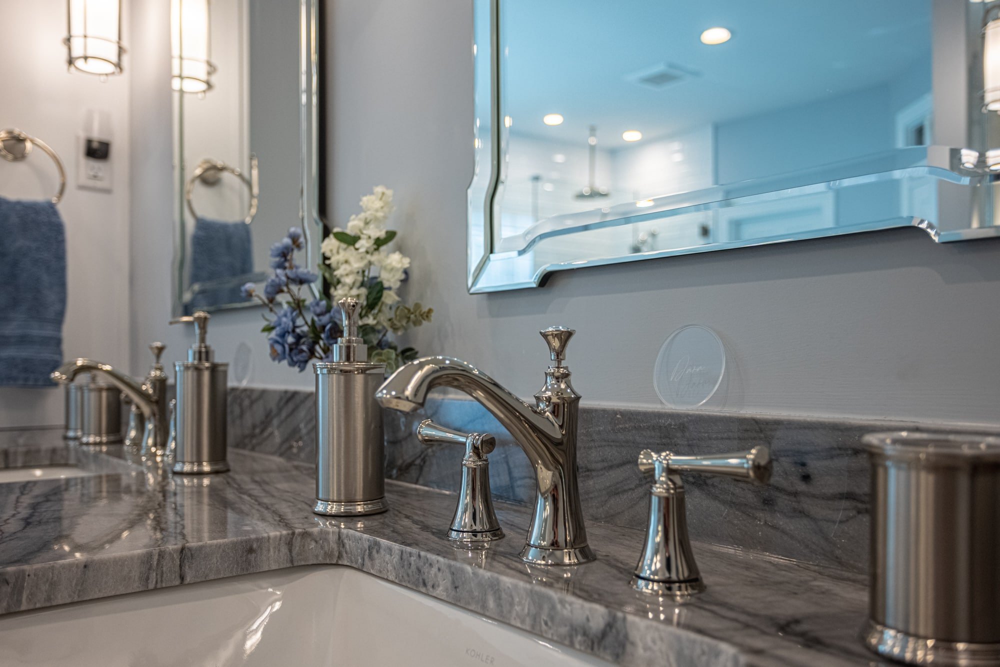 Bathroom faucet and marble countertop with mirror and accessories by Legacy Builders Group in Greater Cincinnati