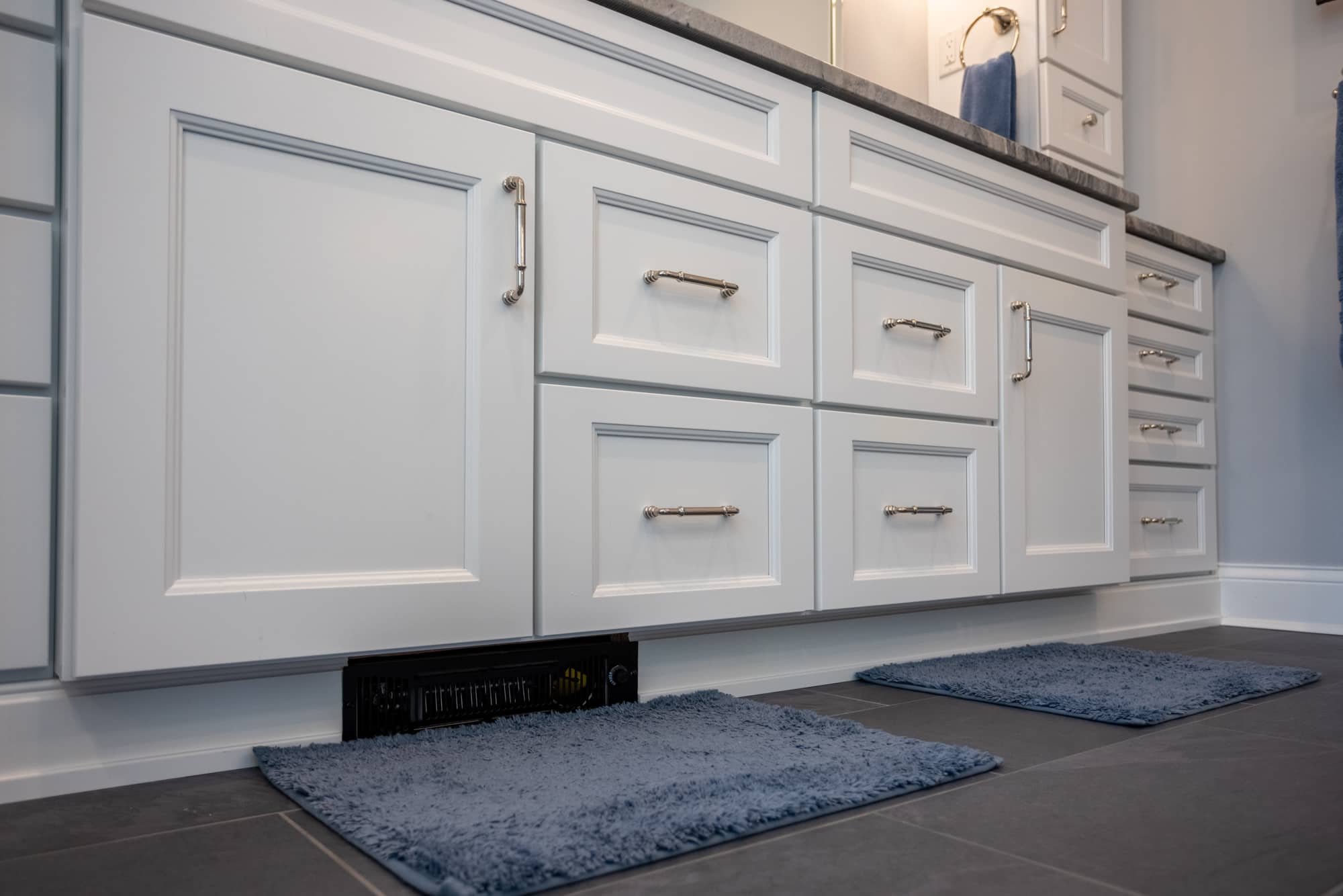 Bathroom vanity base with white cabinetry, brushed hardware, and floor mats by Legacy Builders Group in Greater Cincinnati