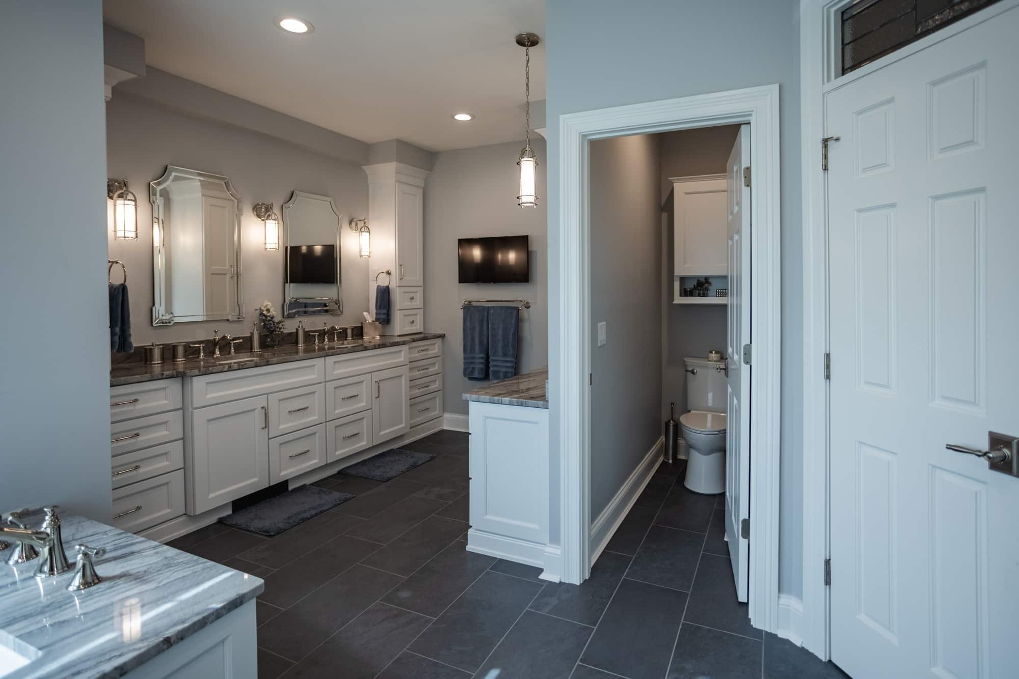 Bathroom with double vanity, separate toilet room, and tile flooring by Legacy Builders Group in Greater Cincinnati