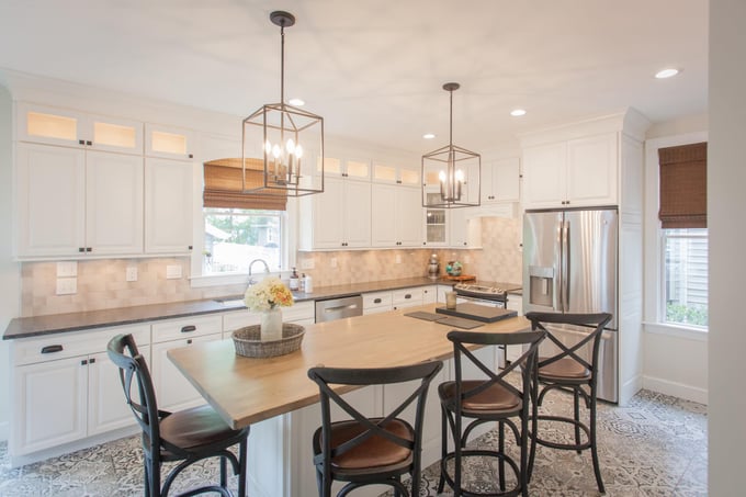 Cincinnati area kitchen with white cabinetry, wood island countertop, patterned tile flooring, and pendant lighting