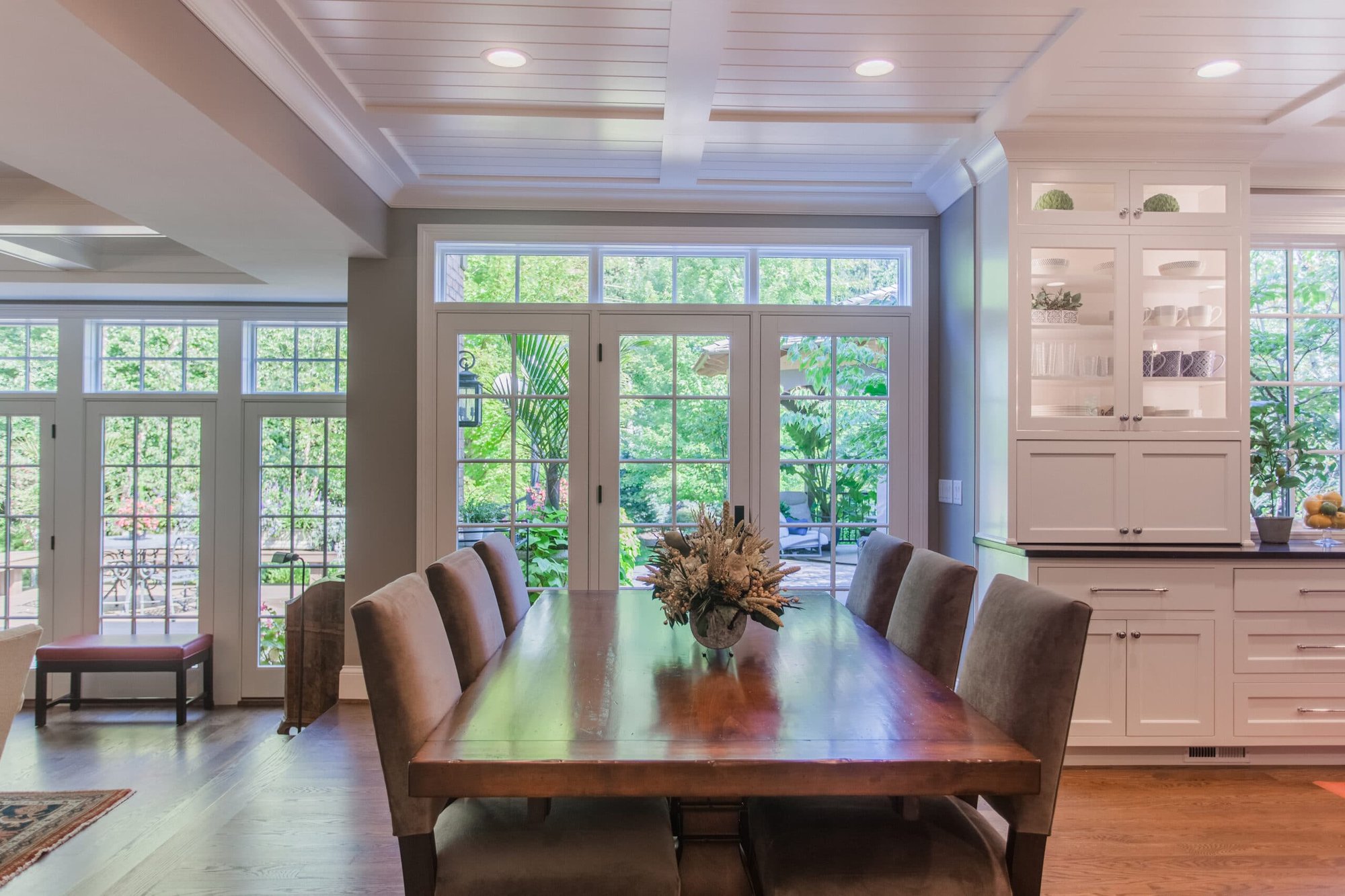 Cincinnati dining room with wood table, coffered ceiling, French doors, and built-in white cabinetry