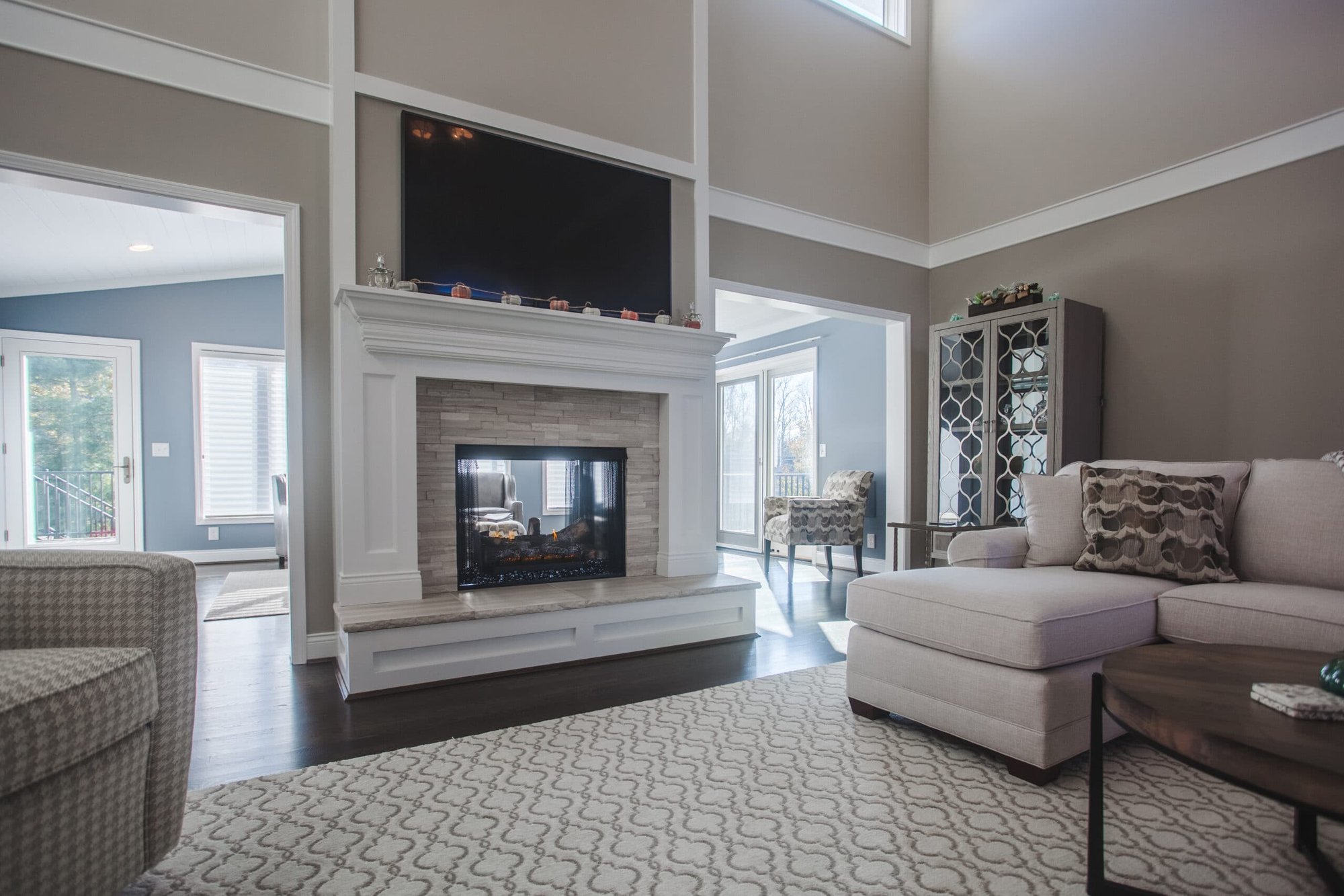 Cincinnati living room with built-in fireplace, wall-mounted TV, sectional sofa, and large windows in a bright, open space