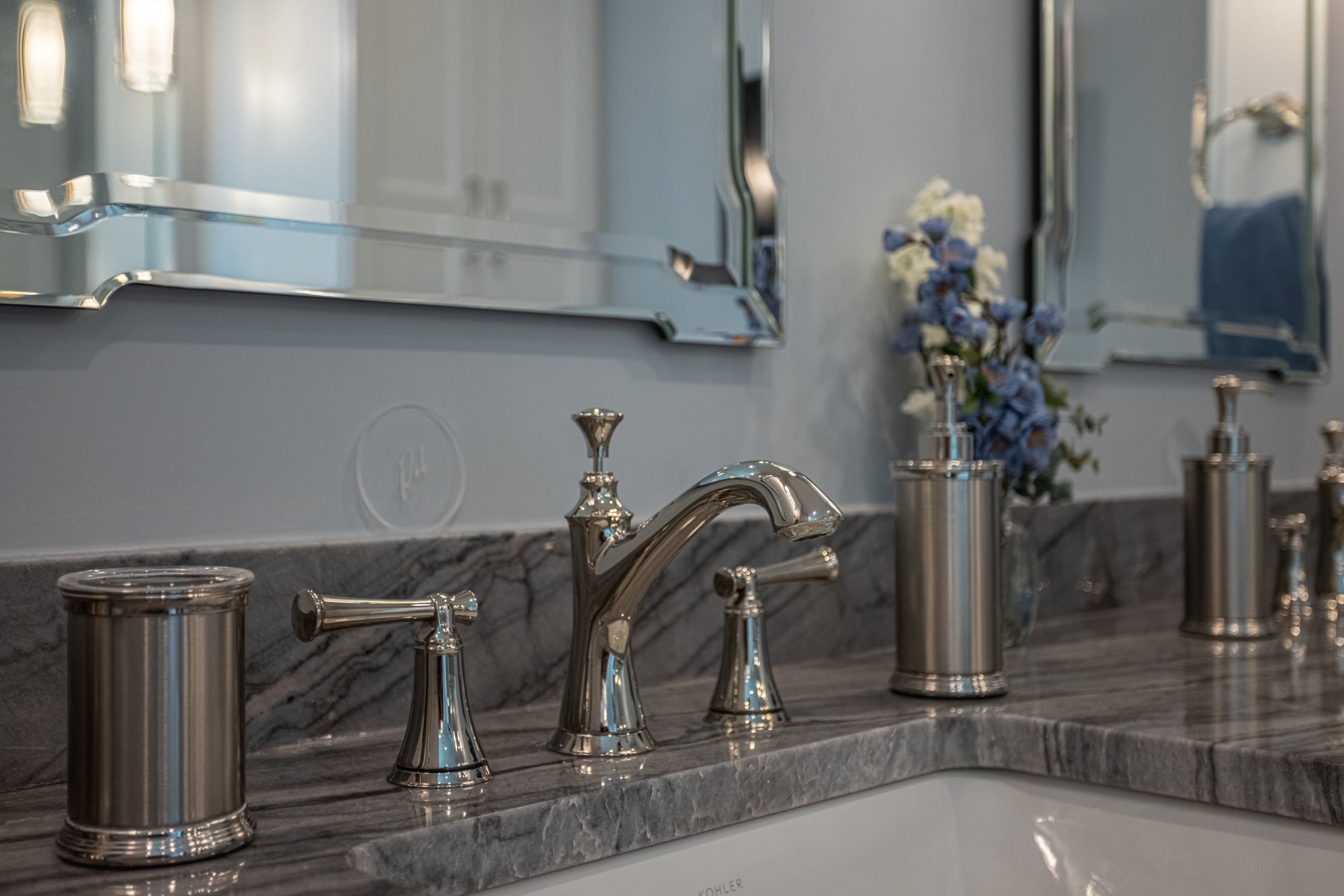 Close-up of bathroom faucet, marble countertop, and accessories by Legacy Builders Group in Greater Cincinnati