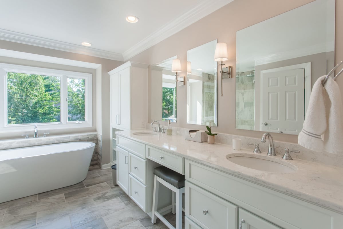Double vanity with porcelain tub by window in Cincinnati bathroom remodel by Legacy Builders
