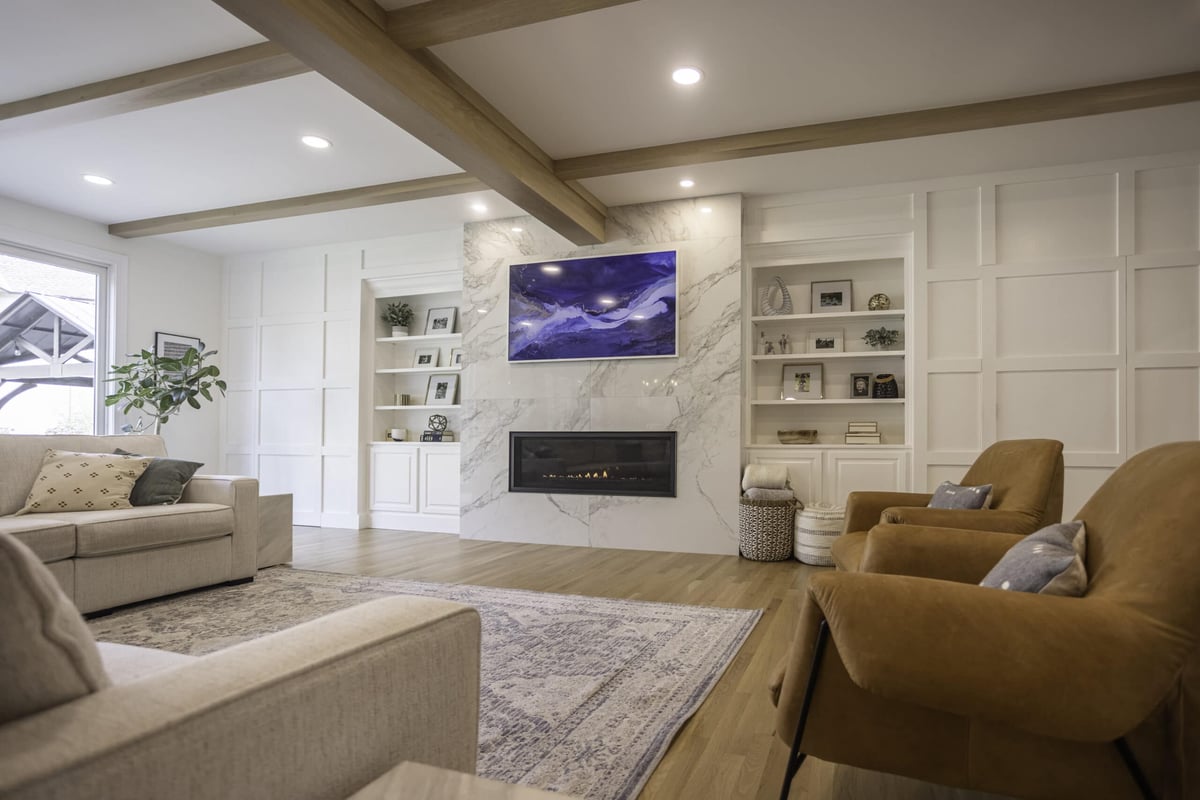 First-floor addition interior with built-in entertainment system and stone fireplace surround by Legacy Builders