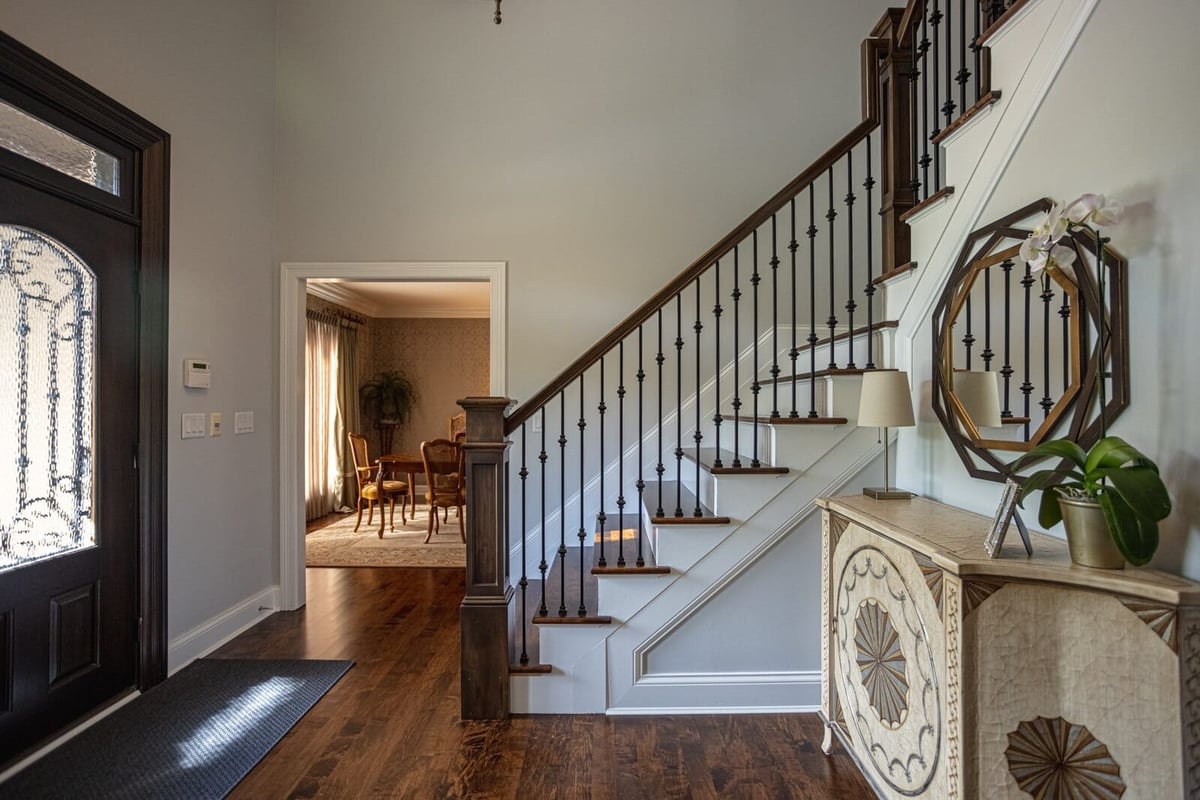 Foyer remodel with staircase and entryway console by Legacy Builders