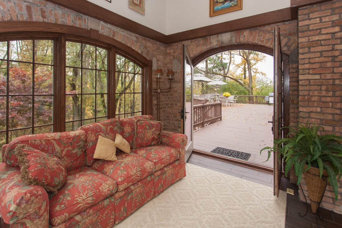 Hyde Park, Ohio sunroom addition with arched doors open to deck by Legacy Builders