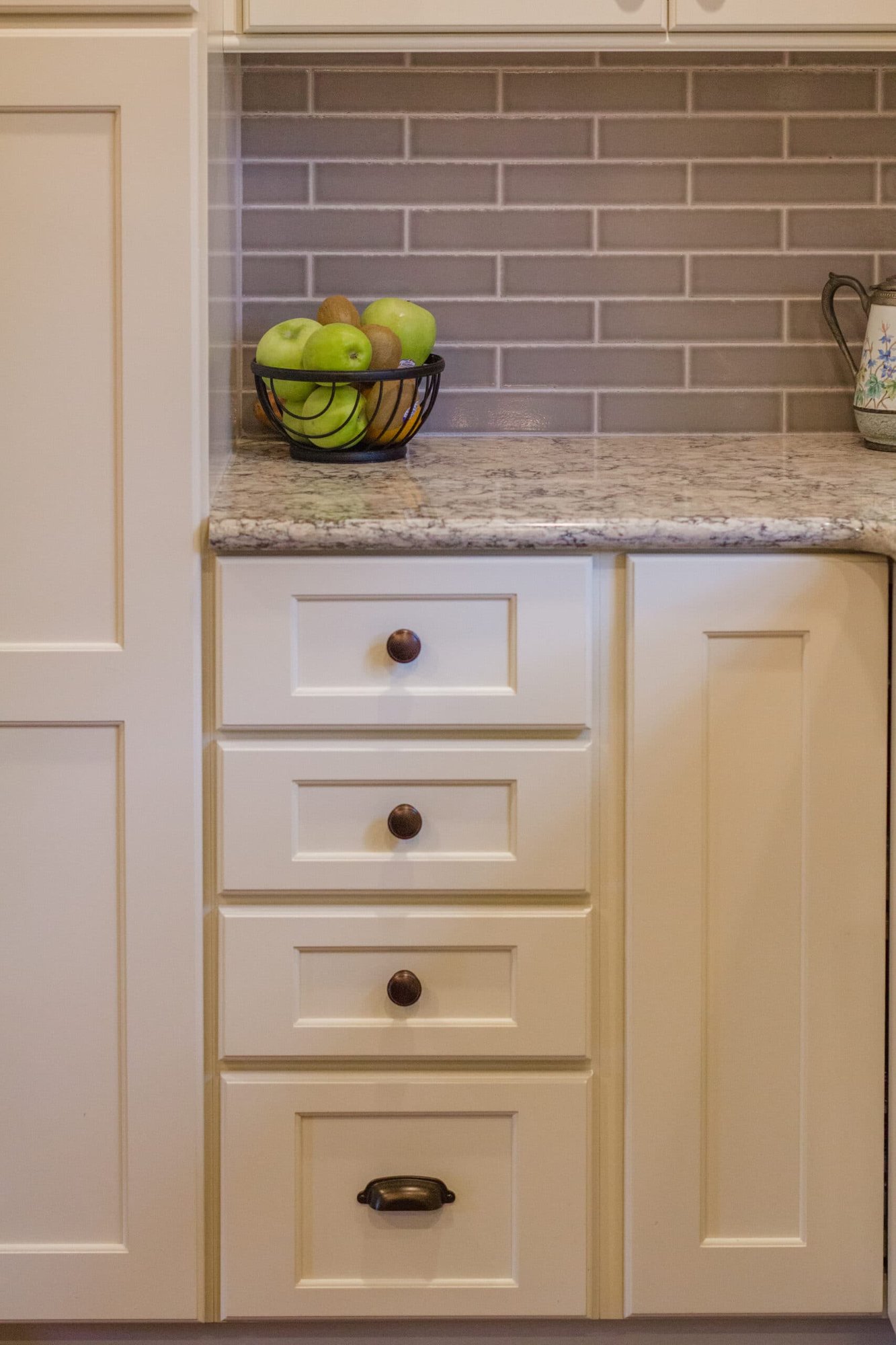 Kitchen cabinetry with granite countertop, tile backsplash, and built-in drawers in a Cincinnati home