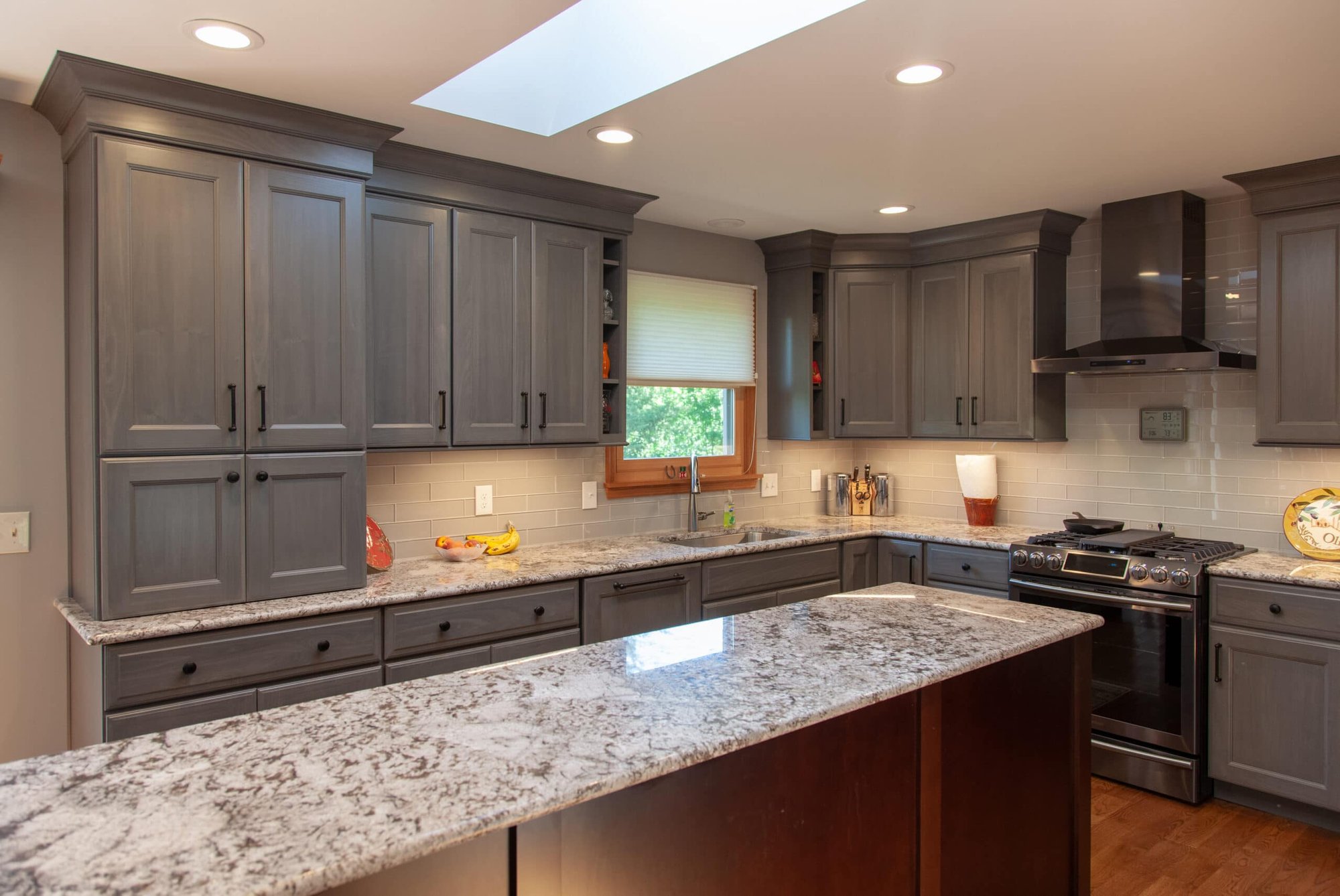Kitchen remodel by Legacy Builders Group with gray cabinetry, large quartz island, and skylight in Cincinnati, OH