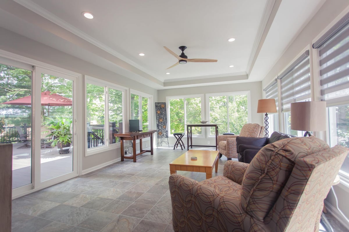 Madeira sunroom addition with recessed lighting and glass front doors to backyard deck