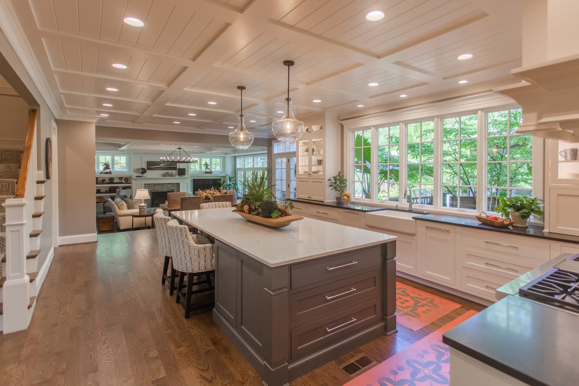 Montgomery, OH kitchen with gray island, white cabinetry, large windows, and open living space