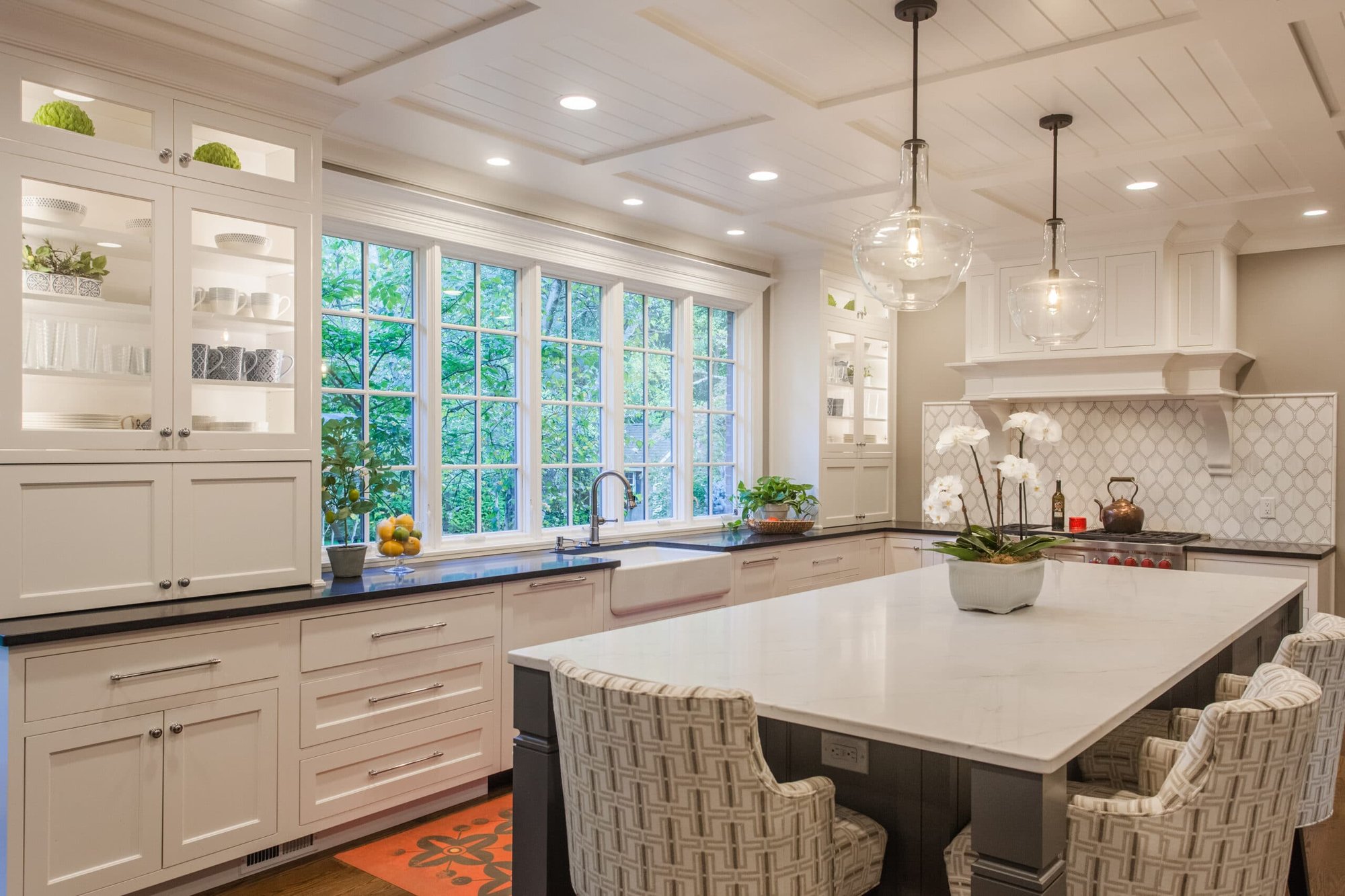 Montgomery, OH kitchen with large island, woven stools, glass pendants, built-ins, and window over the sink