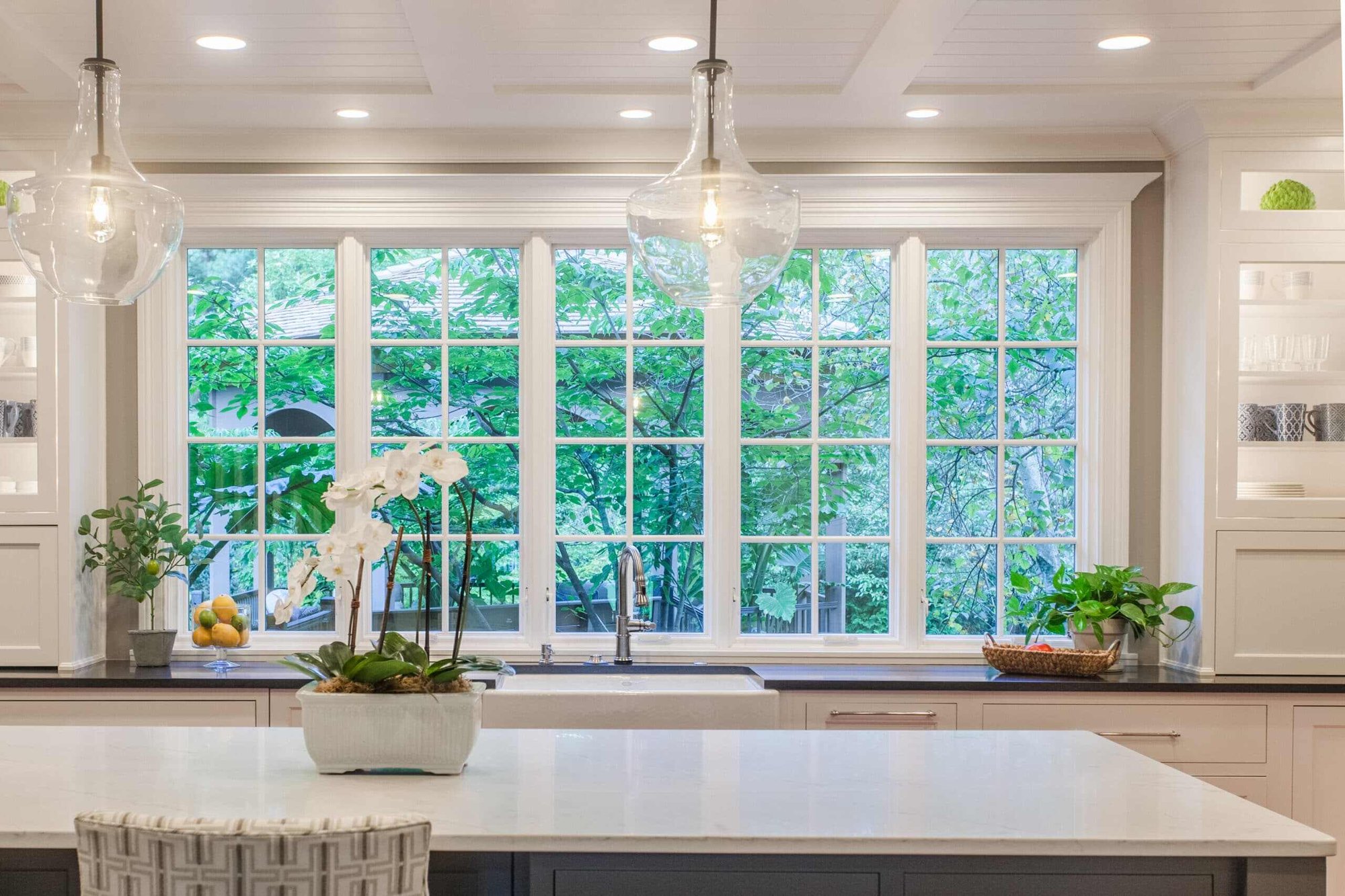Montgomery, OH kitchen with large windows, white island, pendant lights, and built-in cabinetry