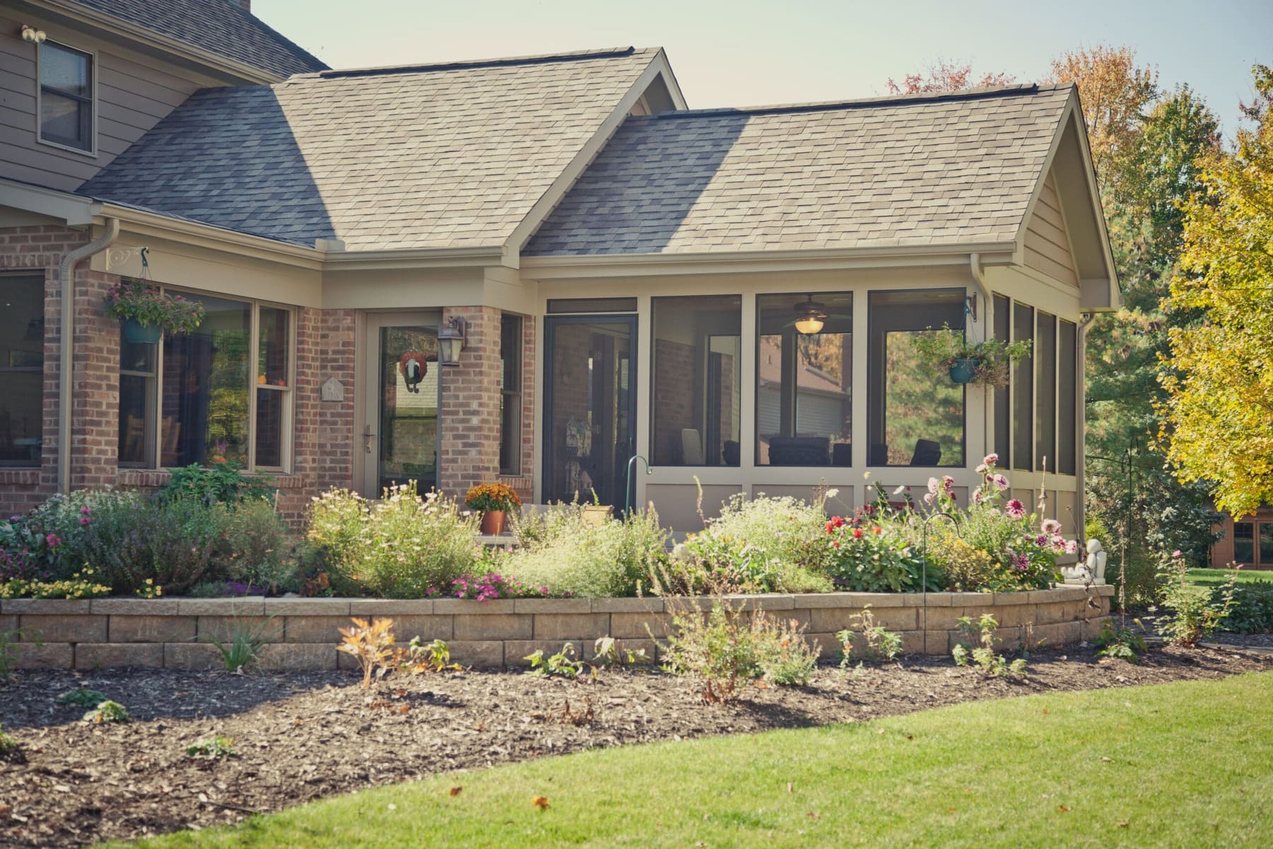 Screened porch addition with garden beds and brick exterior by Legacy Builders Group in Greater Cincinnati