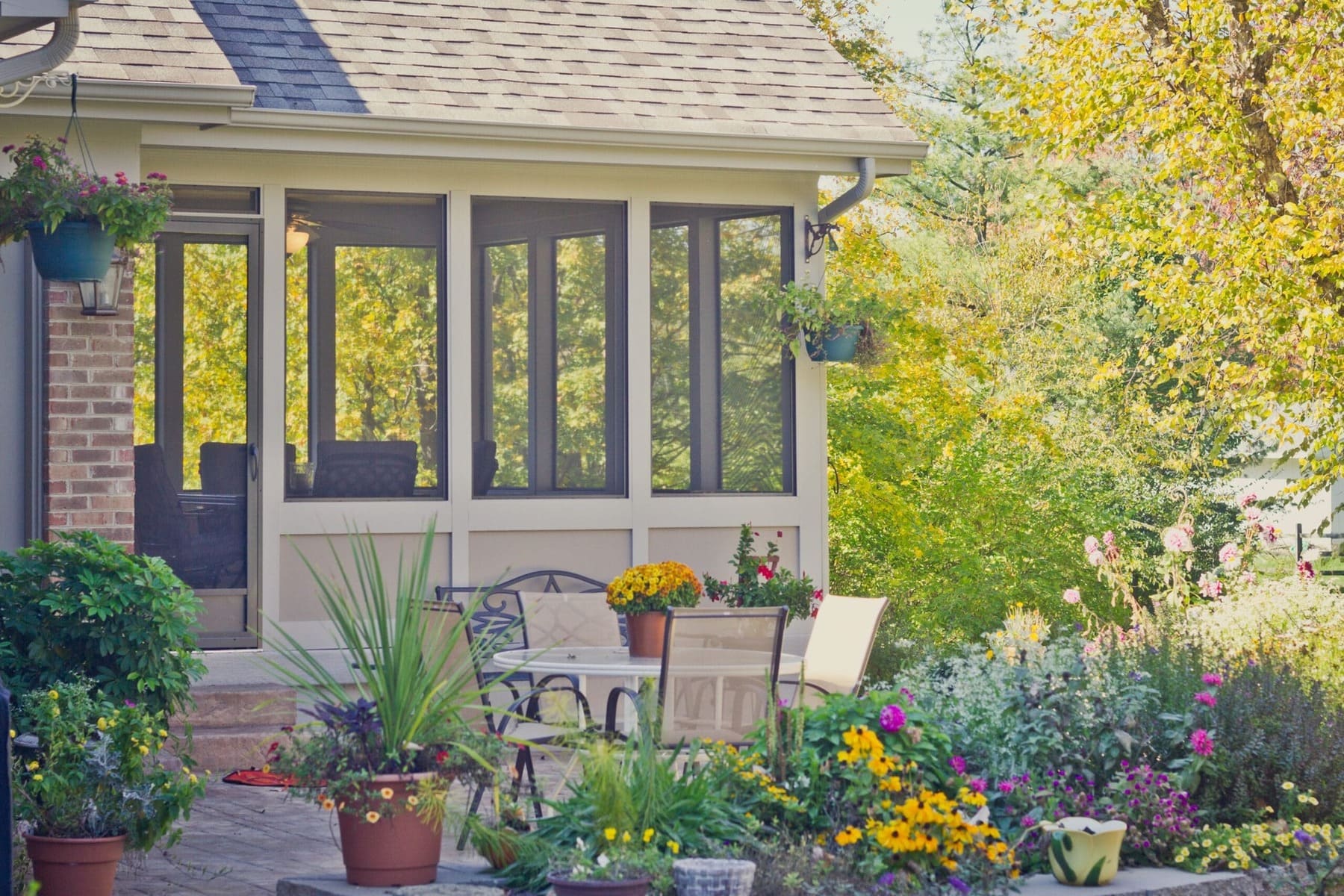 Screened porch with outdoor seating and landscaped garden by Legacy Builders Group in Greater Cincinnati