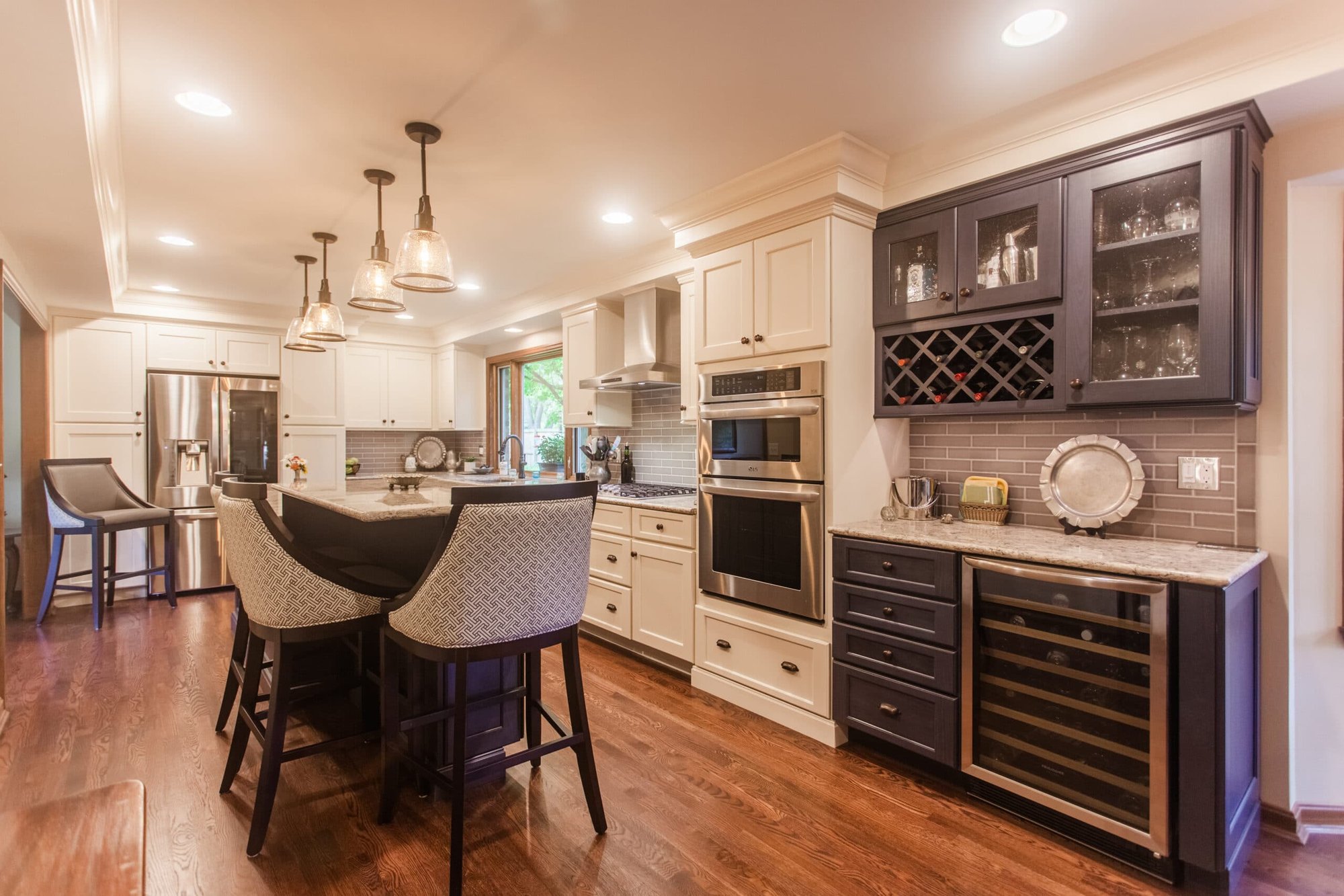 Spacious kitchen with island seating, mixed cabinetry, wine storage, and pendant lighting in a Cincinnati home