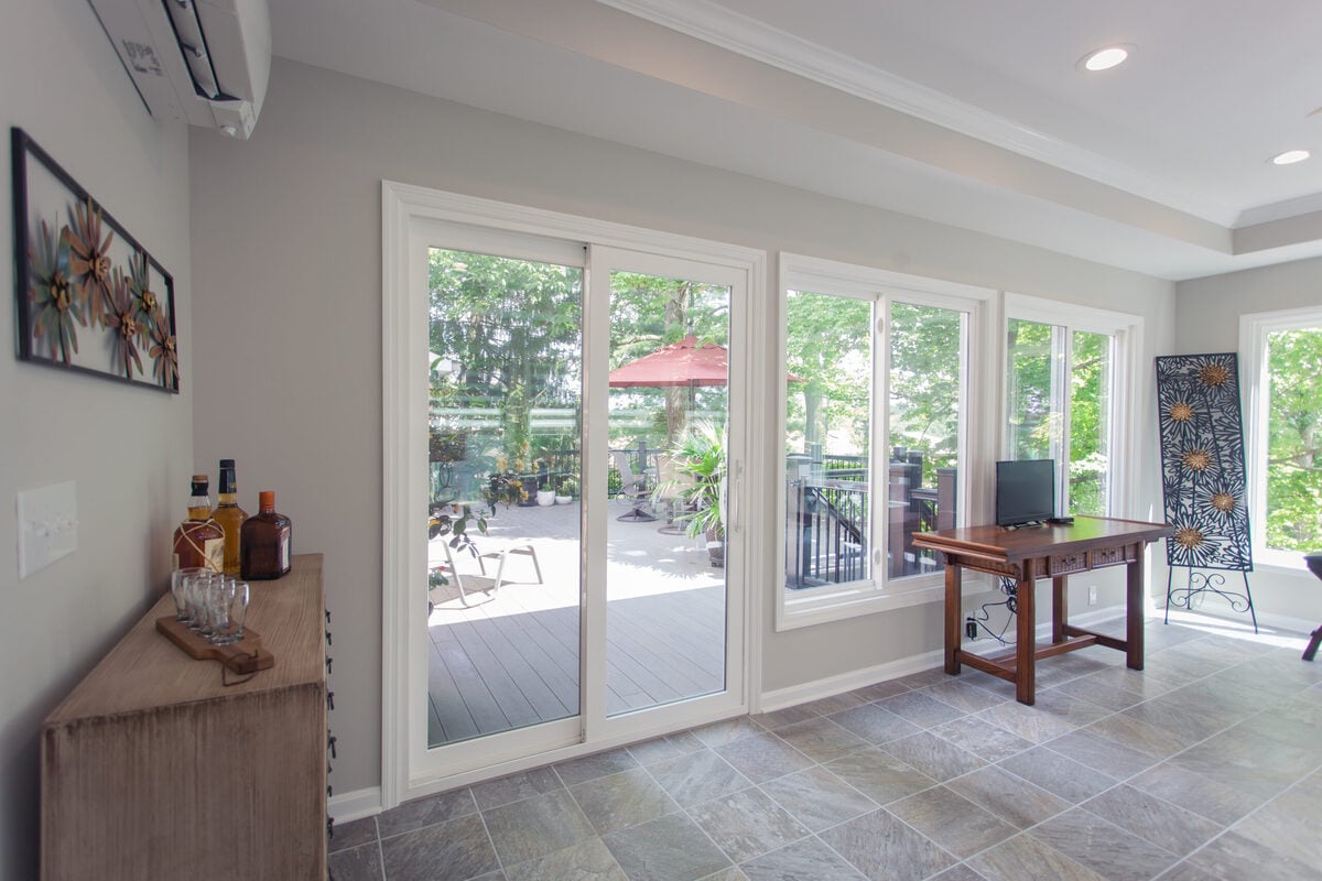 Sunroom addition in Madeira, Ohio with sliding glass door to composite deck by Legacy Builders