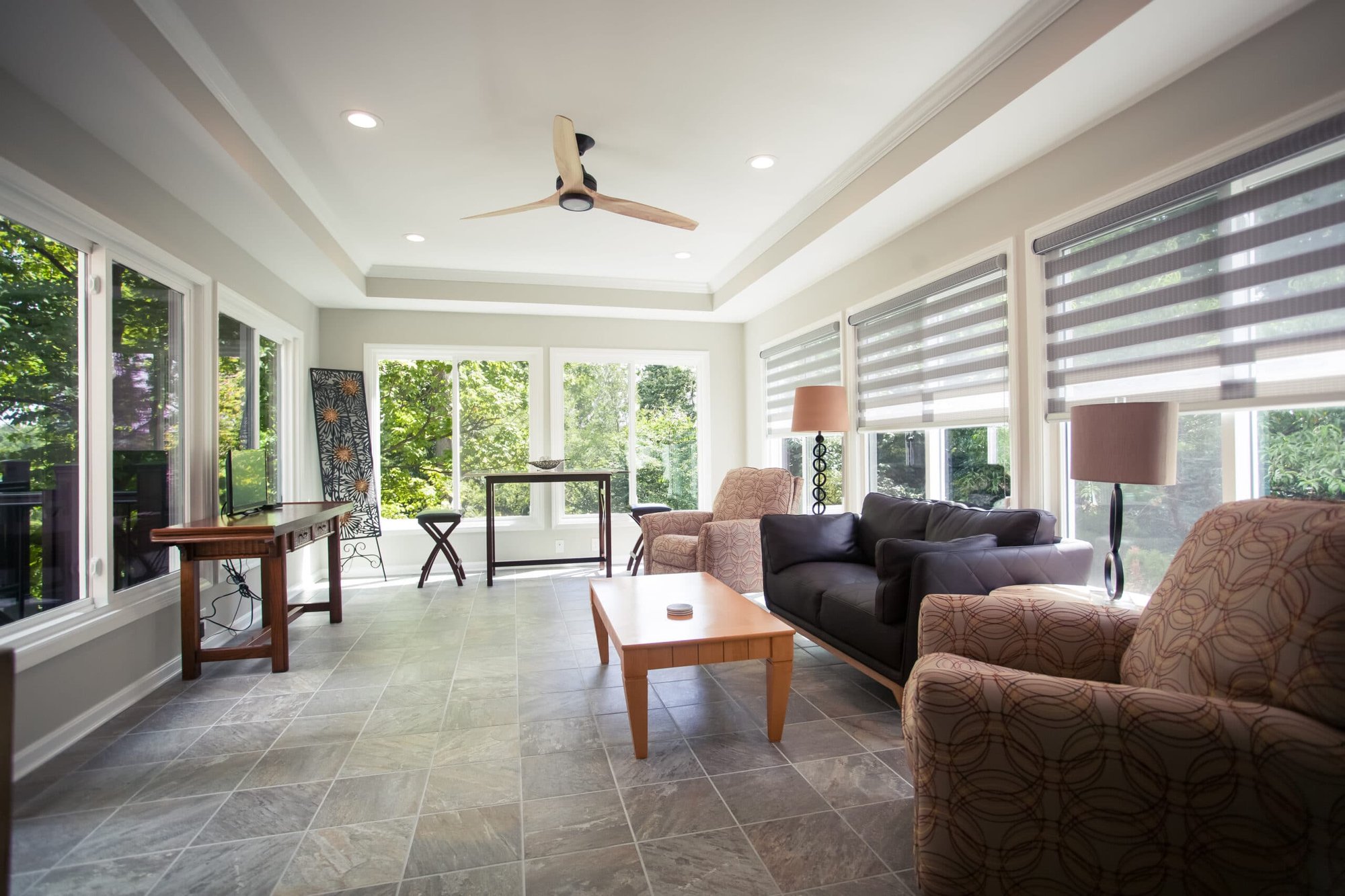 Sunroom with expansive windows, tile flooring, and comfortable seating in Madeira, OH