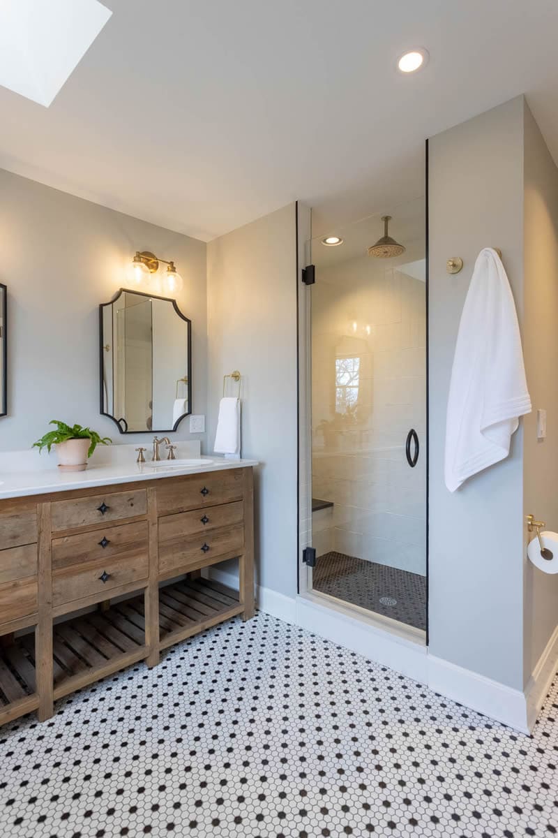 Wooden double vanity next to walk-in shower in Cincinnati bathroom remodel