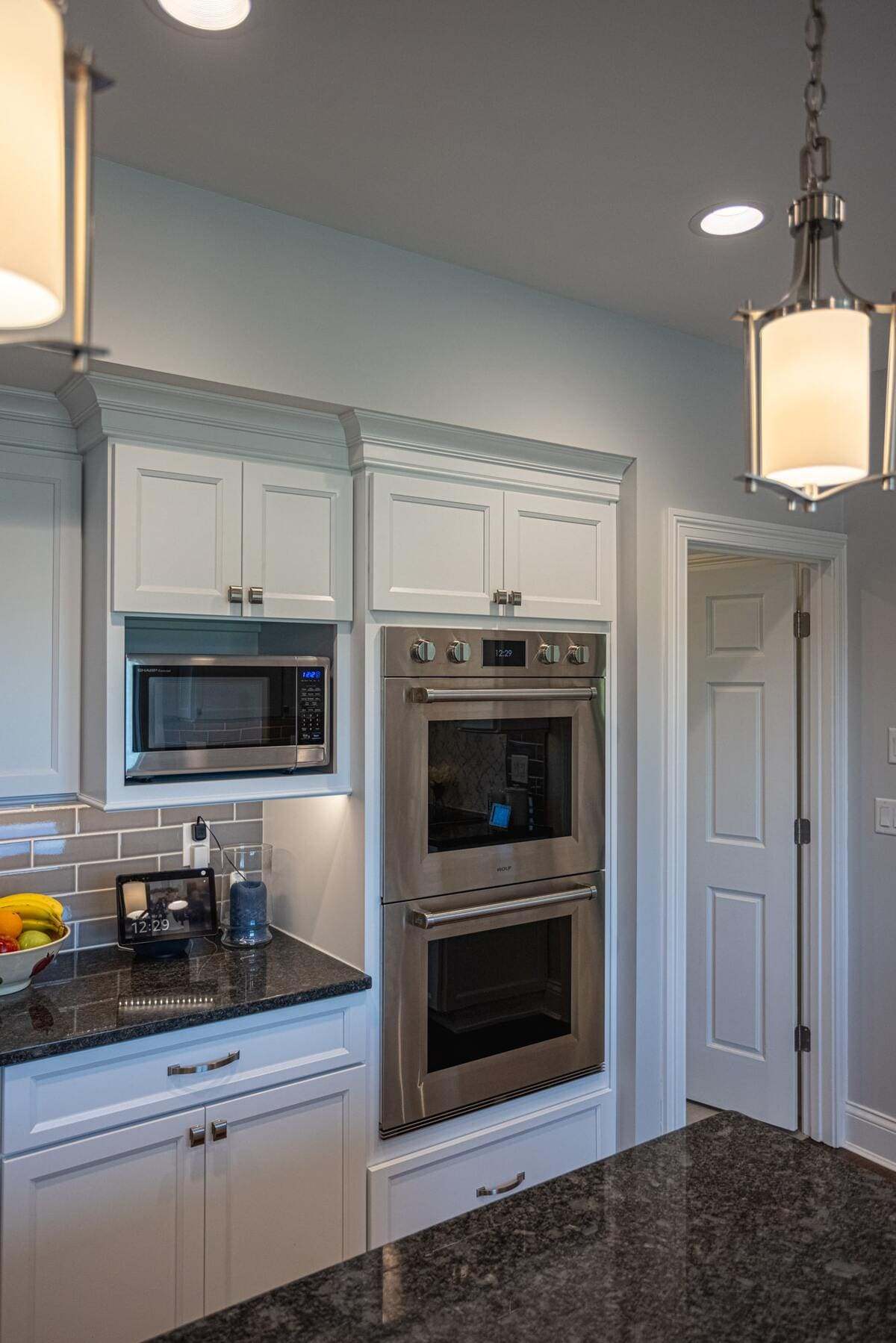 Custom inset double ovens and microwave in luxury kitchen remodel