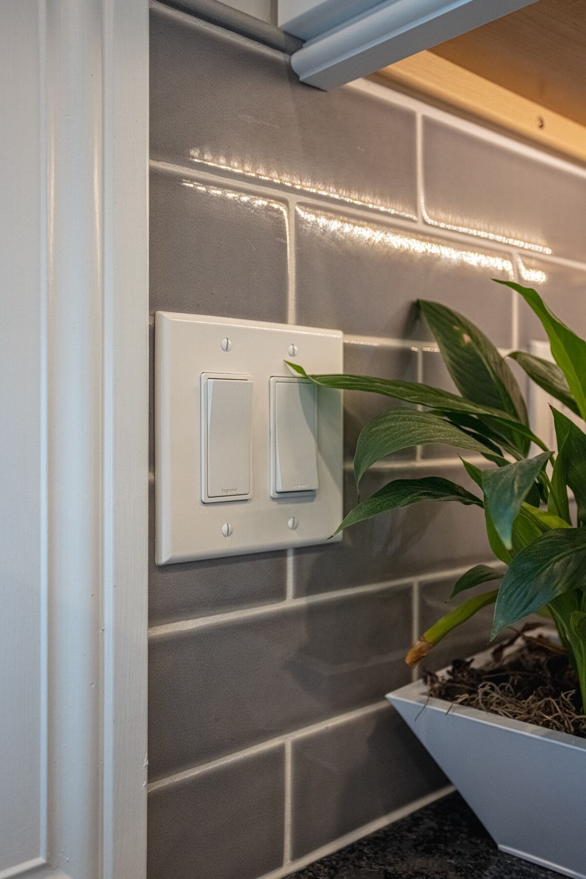 Light switch on gray subway tile in kitchen