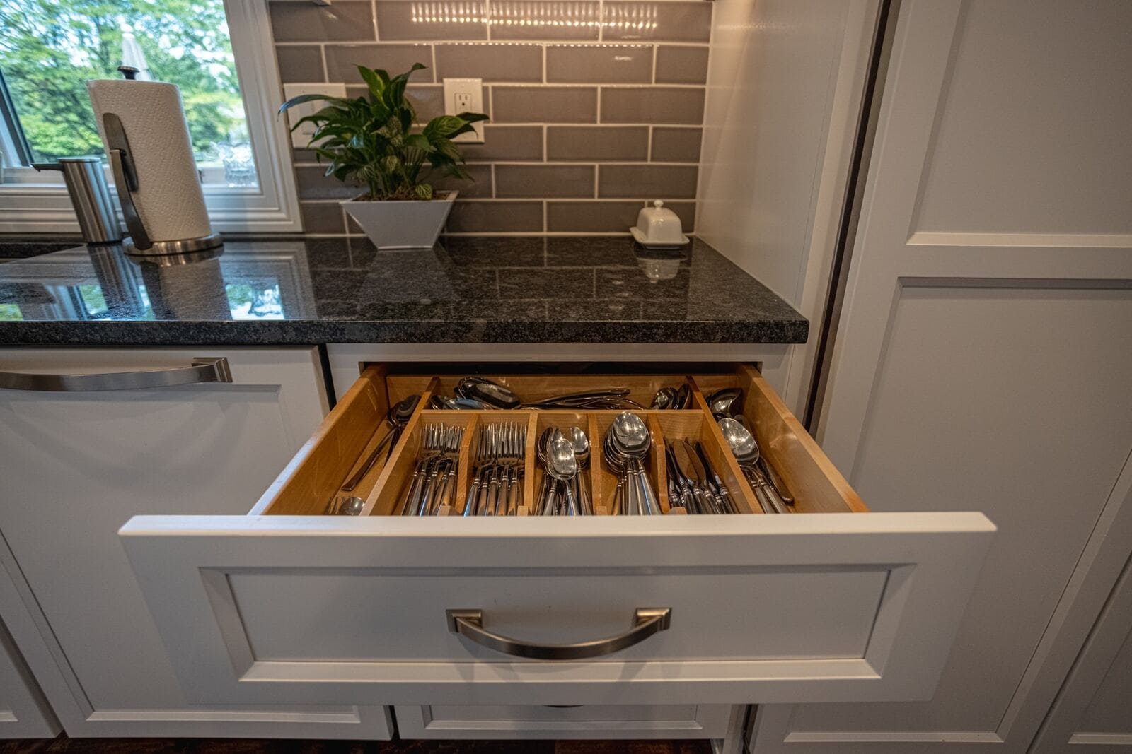 White shaker cabinet drawer pulled out with chrome pulls