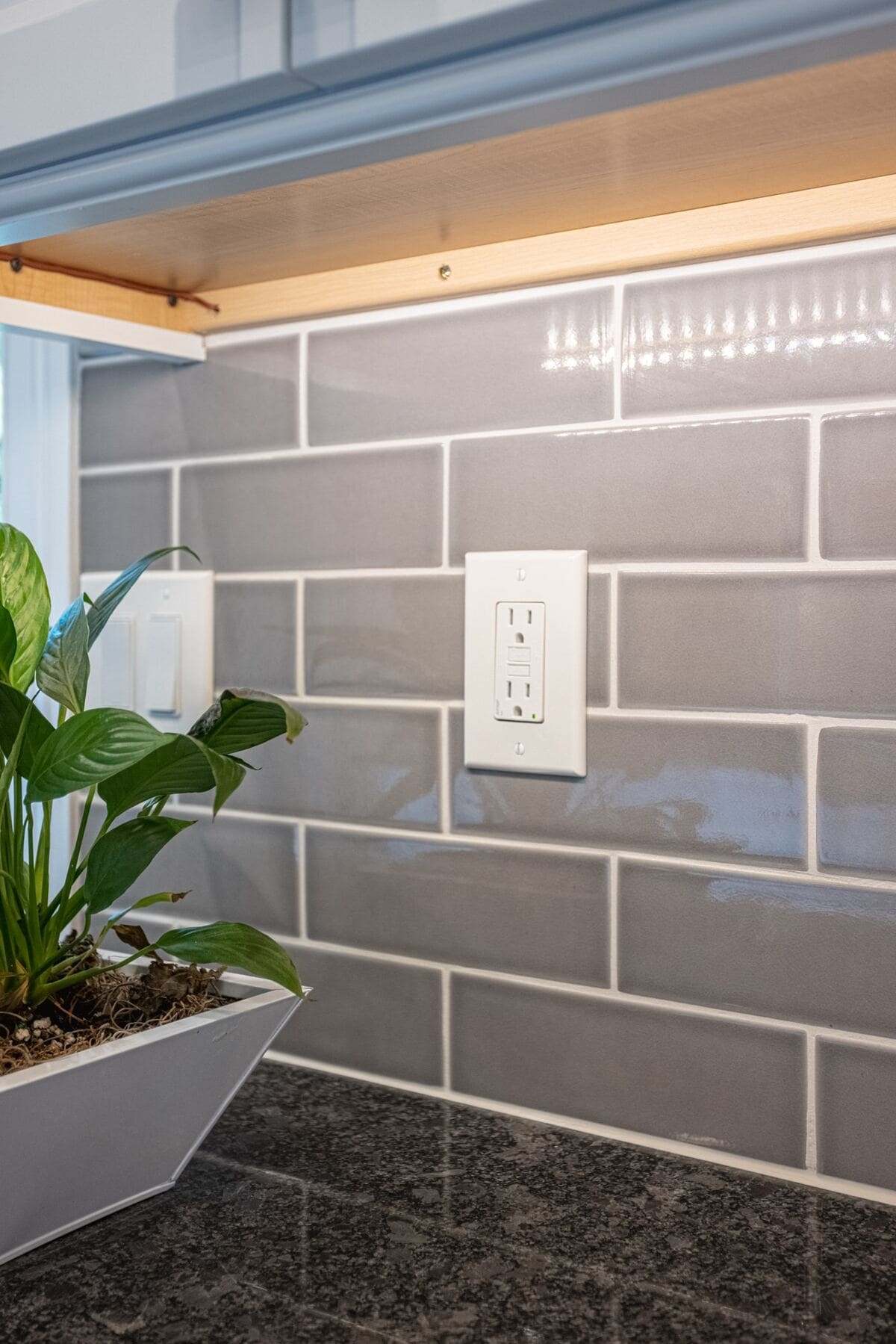 Electrical outlet above kitchen countertop next to light switch