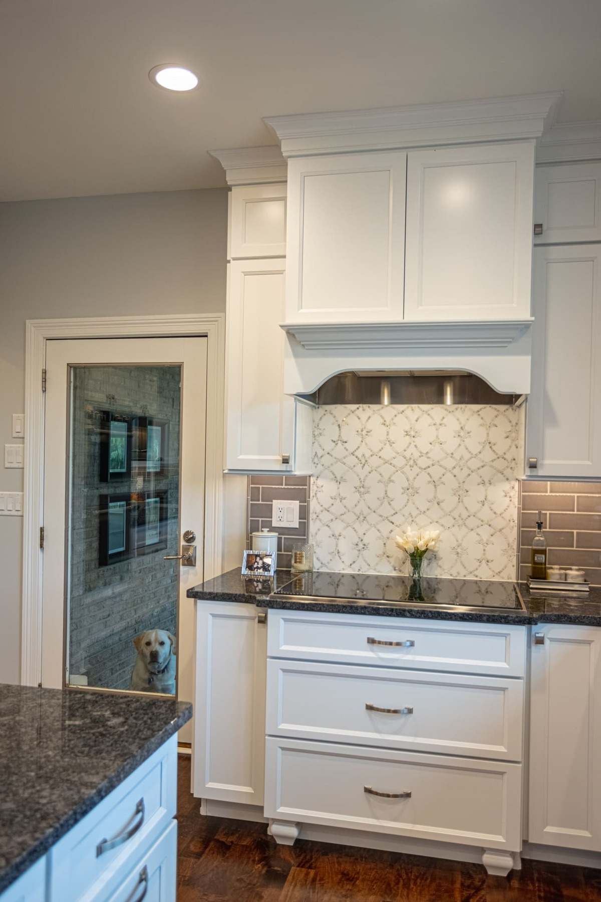 Kitchen range hood with pattern backsplash and shaker cabinets