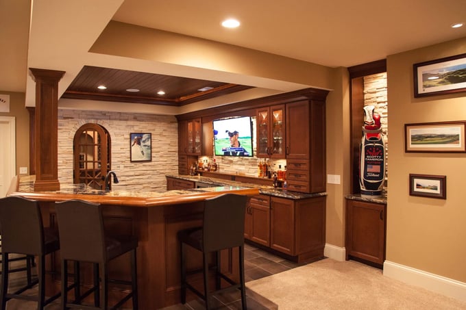 Basement bar remodel with recessed lighting and stone wall accent