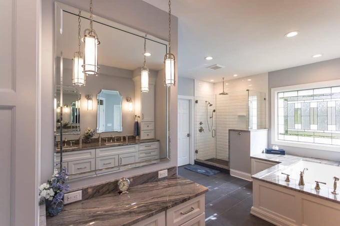 Spacious Cincinnati bathroom with marble vanity, glass shower, soaking tub, and decorative window