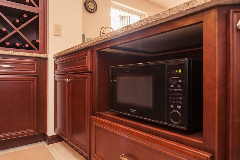Custom wood cabinetry in basement remodel with microwave shelf
