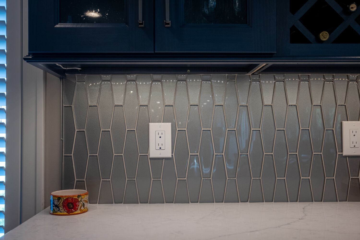 Modern kitchen tile backsplash below glass cabinetry