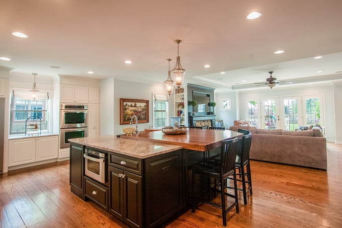 Open-concept first-floor design view of kitchen with living room in back