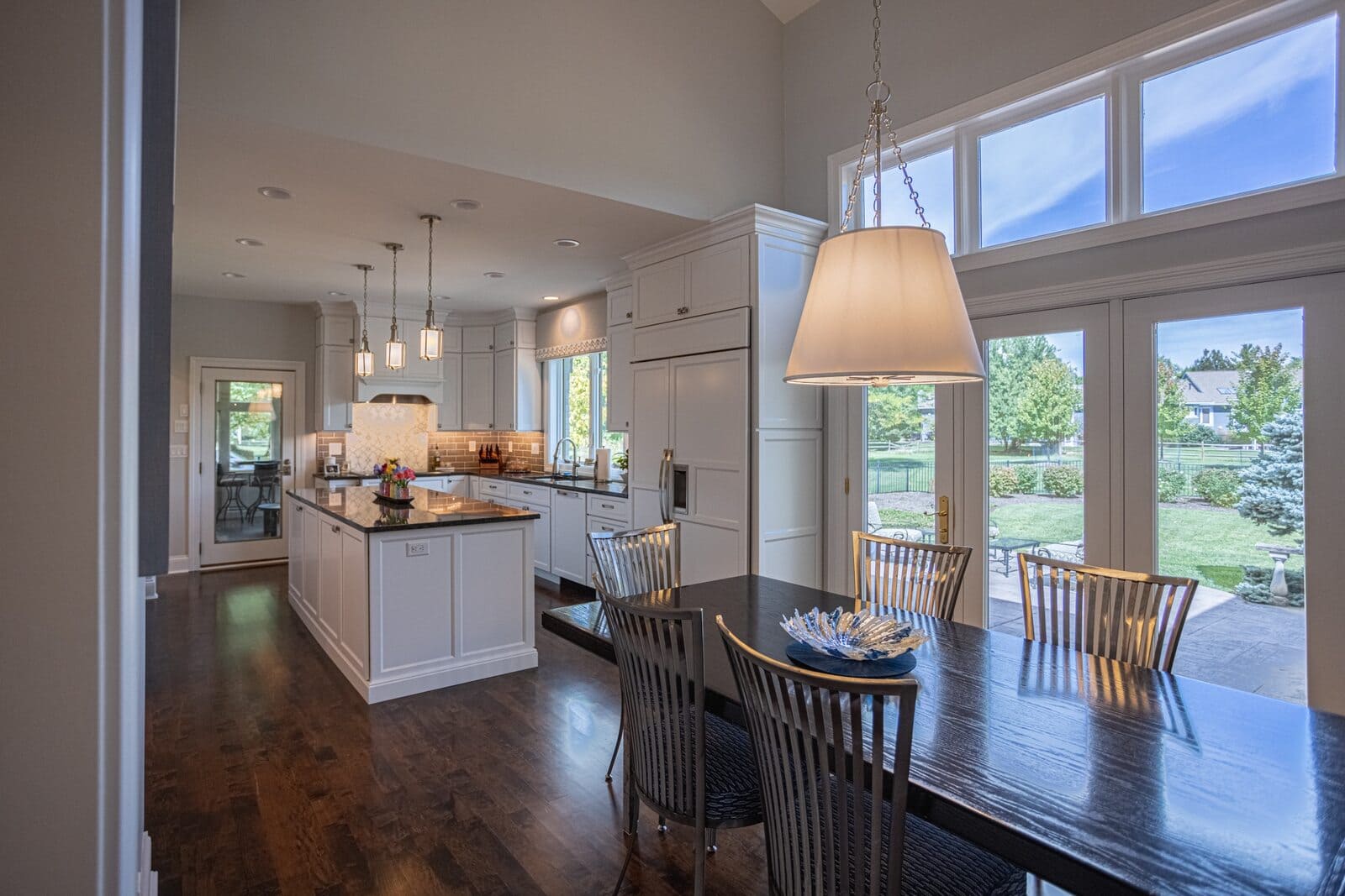 Open concept kitchen remodel and dining table beneath hanging light fixture