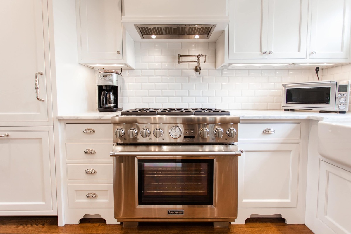 Upscale kitchen remodel stainless steel range with white tile backsplash