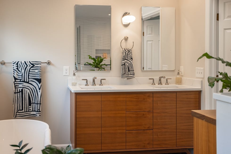bathroom in Cincinnati with double vanity wooden cabinets and abstract black and white towels