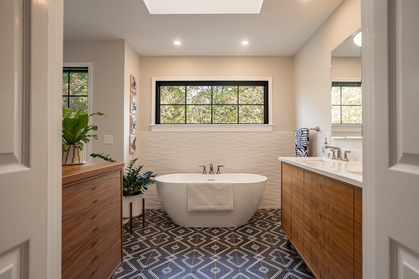 bathroom in Cincinnati with freestanding bathtub geometric floor tiles and large window letting in natural light