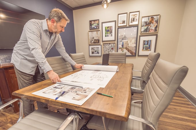Legacy Builders co-founder Chris Otte in office reviewing design-build project plans